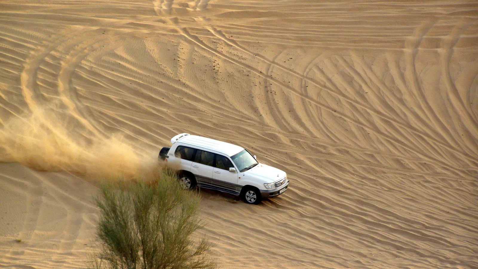 A 4x4 vehicle crosses the sand dunes outside Dubai on a desert safari