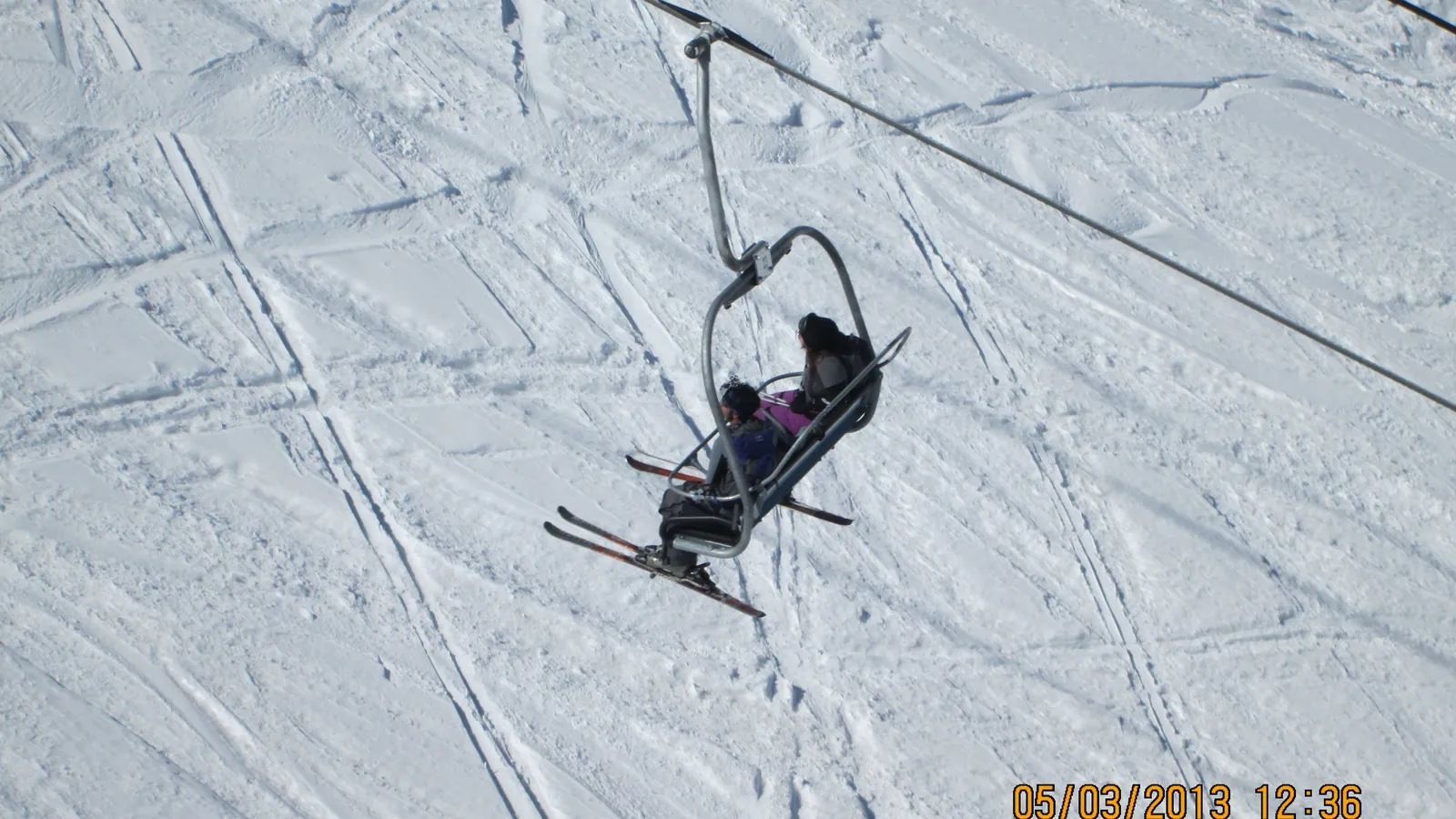 A skier rides a chairlift above the snowy slopes of Gulmarg