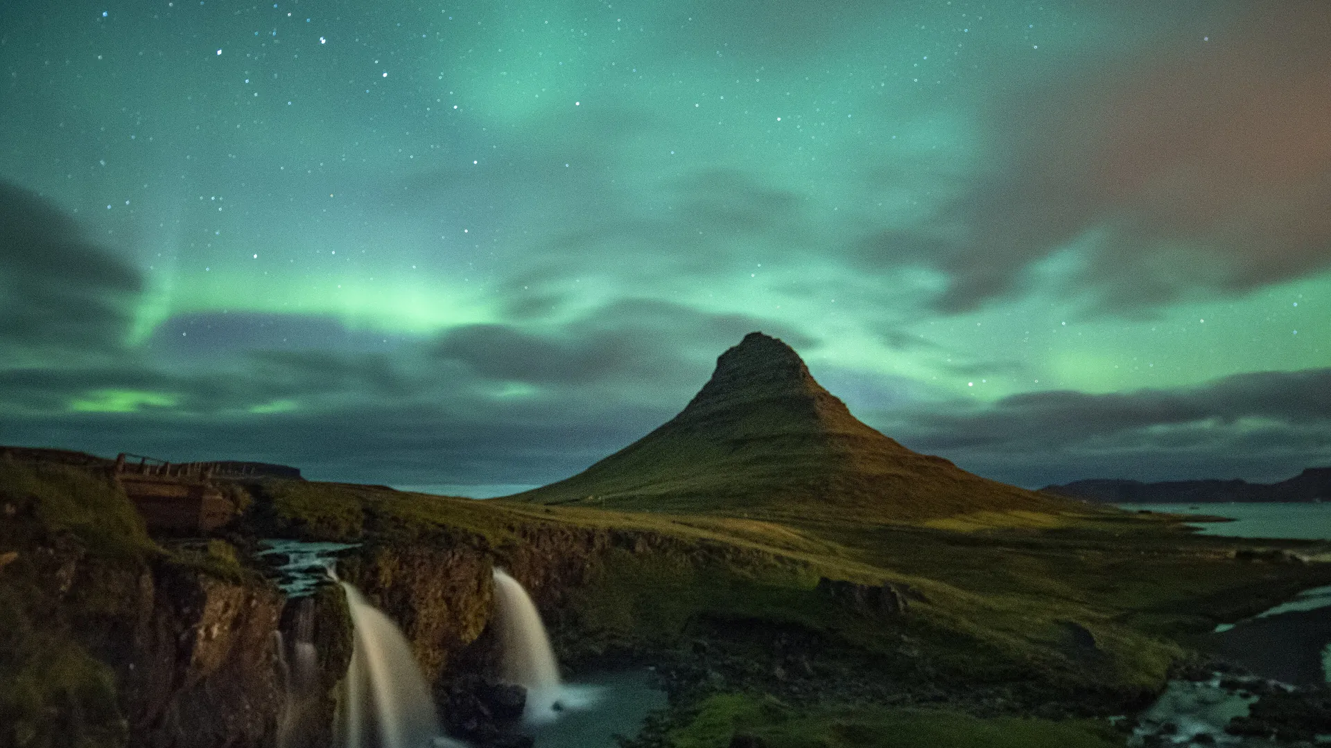 The northern lights dance above Kirkjufell mountain on Iceland's Snæfellsnes peninsula