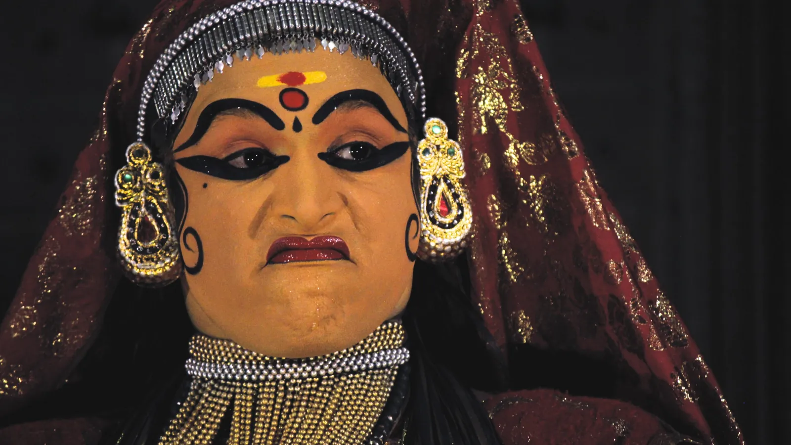 The painted face of a Kathakali performer in traditional make-up