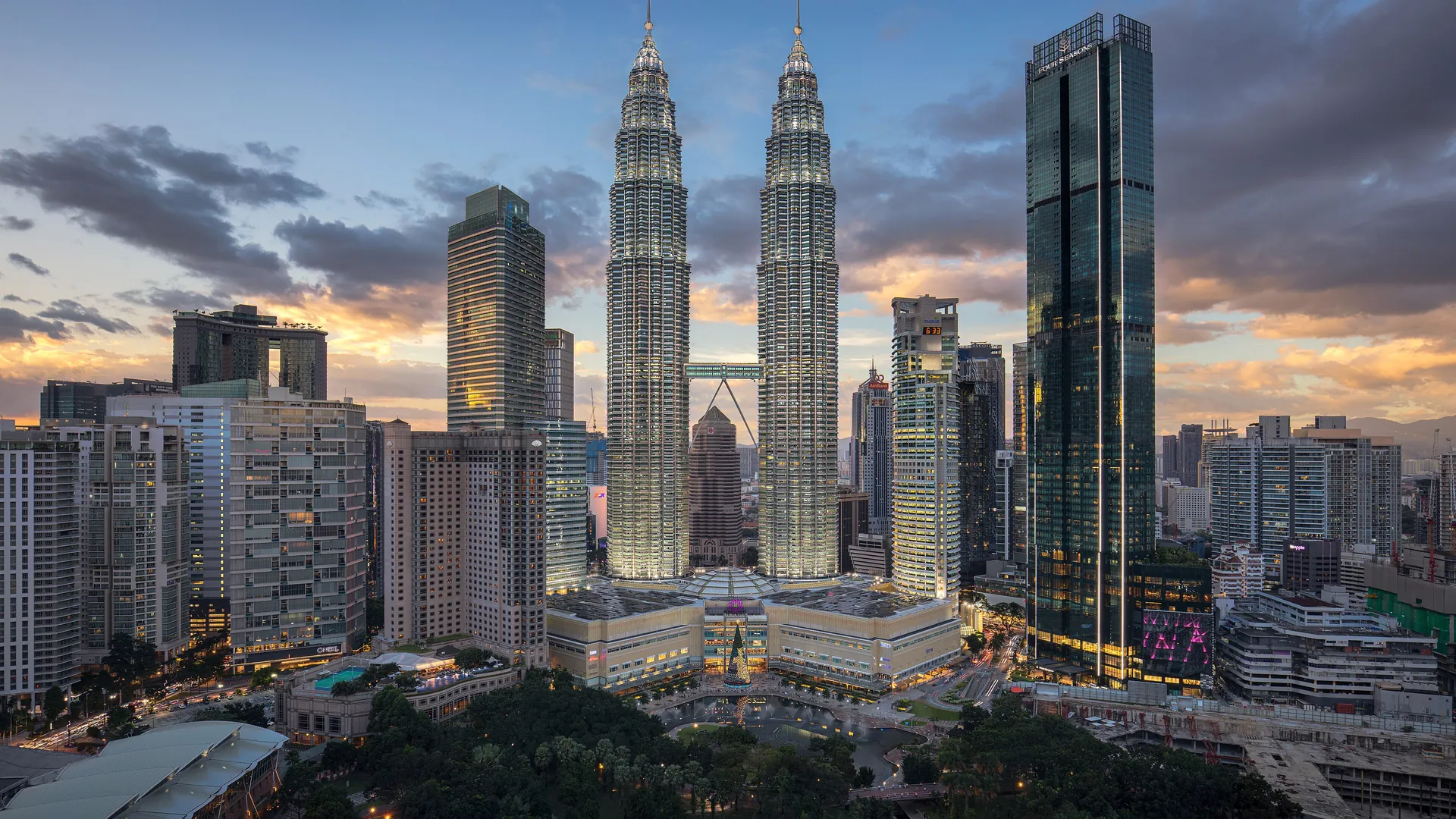 The Petronas Twin Towers rise above the Kuala Lumpur skyline at dusk