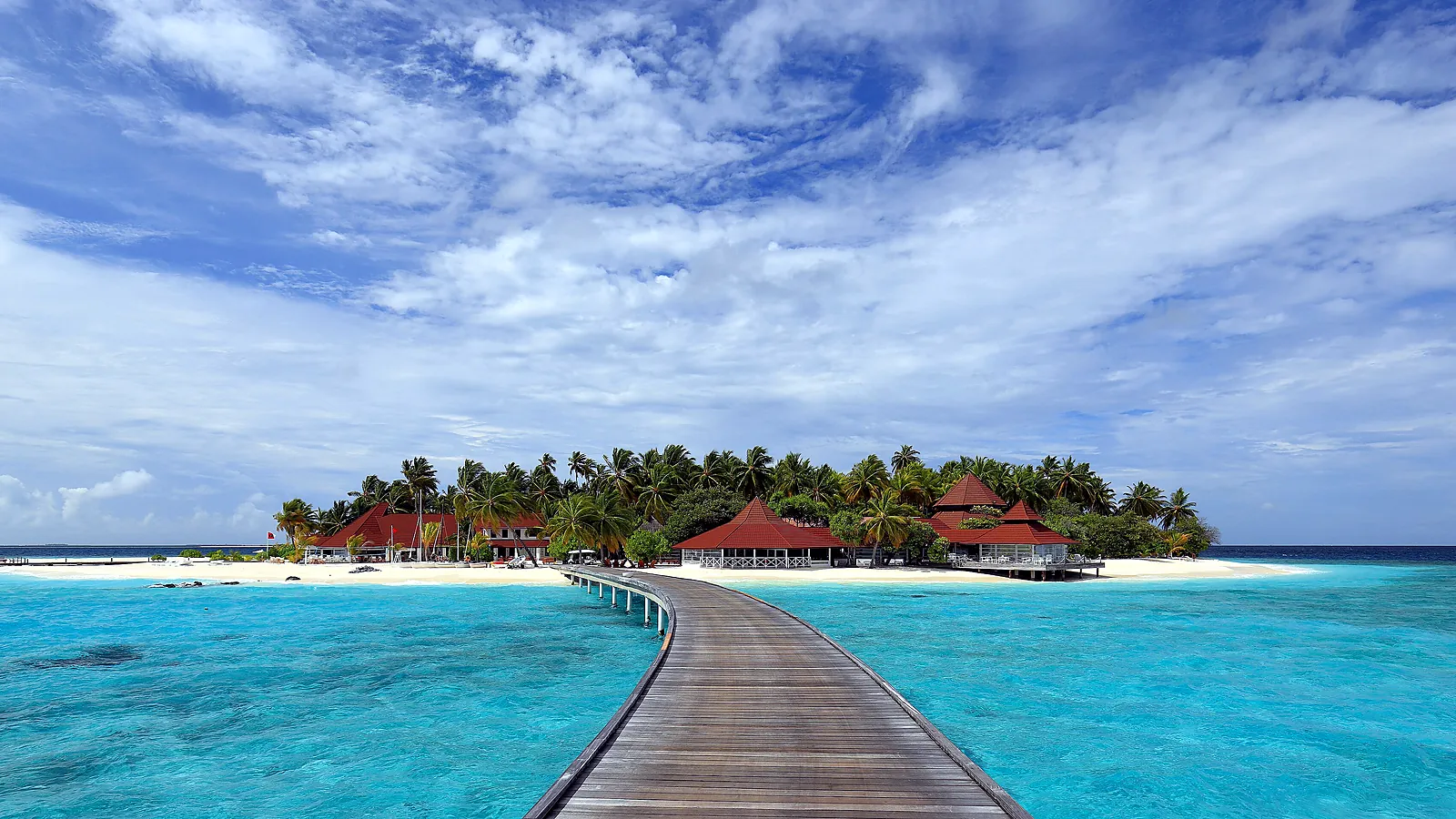 Overwater villas stretching out over the lagoon on a resort island, with steps from each deck straight into the sea