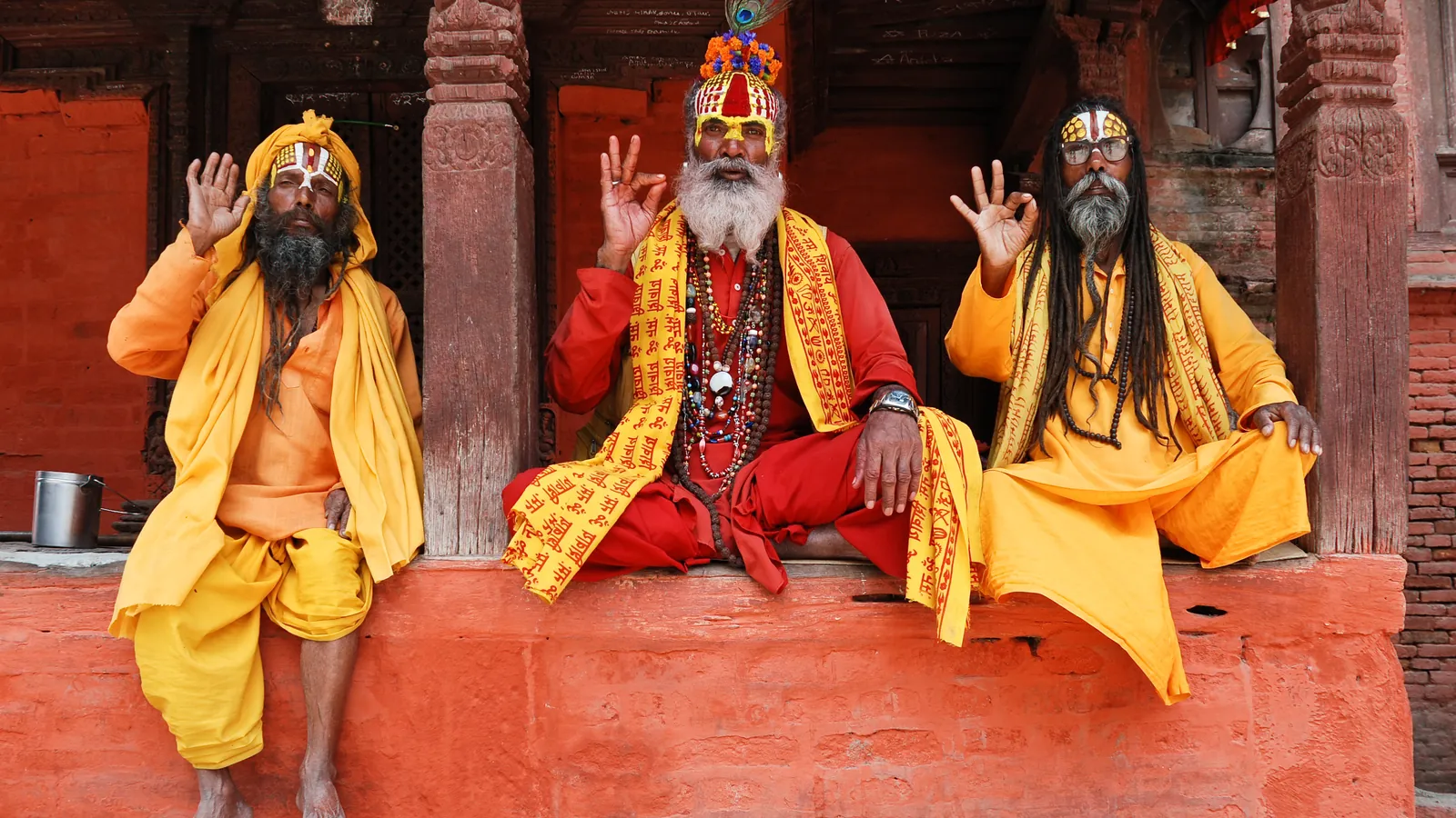 Sadhus in saffron robes sit outside a temple in Kathmandu