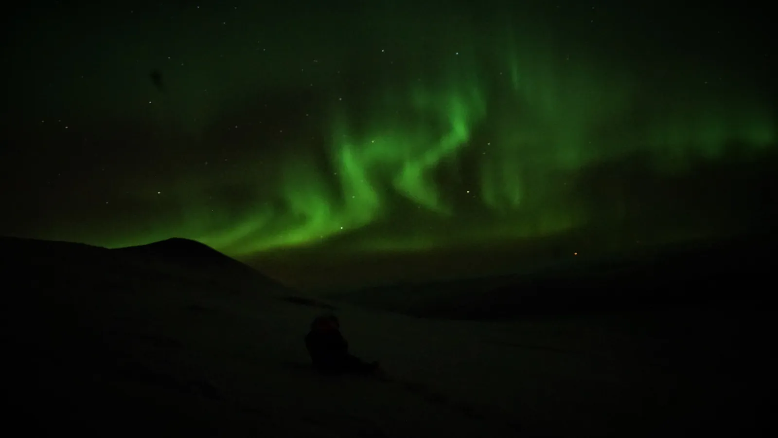 Green aurora ribbons over the mountains near Abisko in Swedish Lapland