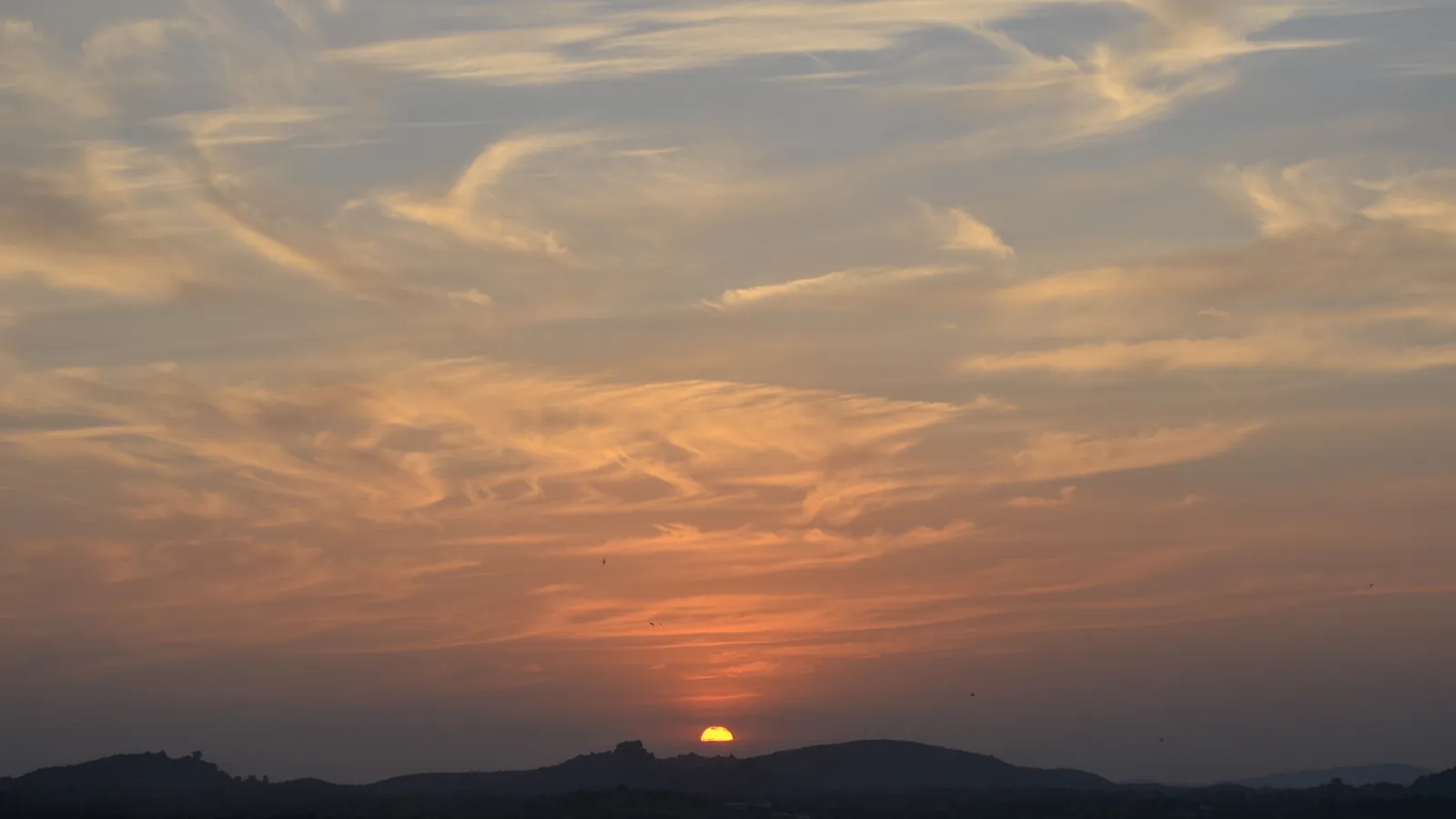 The sun sets over the boulder-strewn hills of Hampi