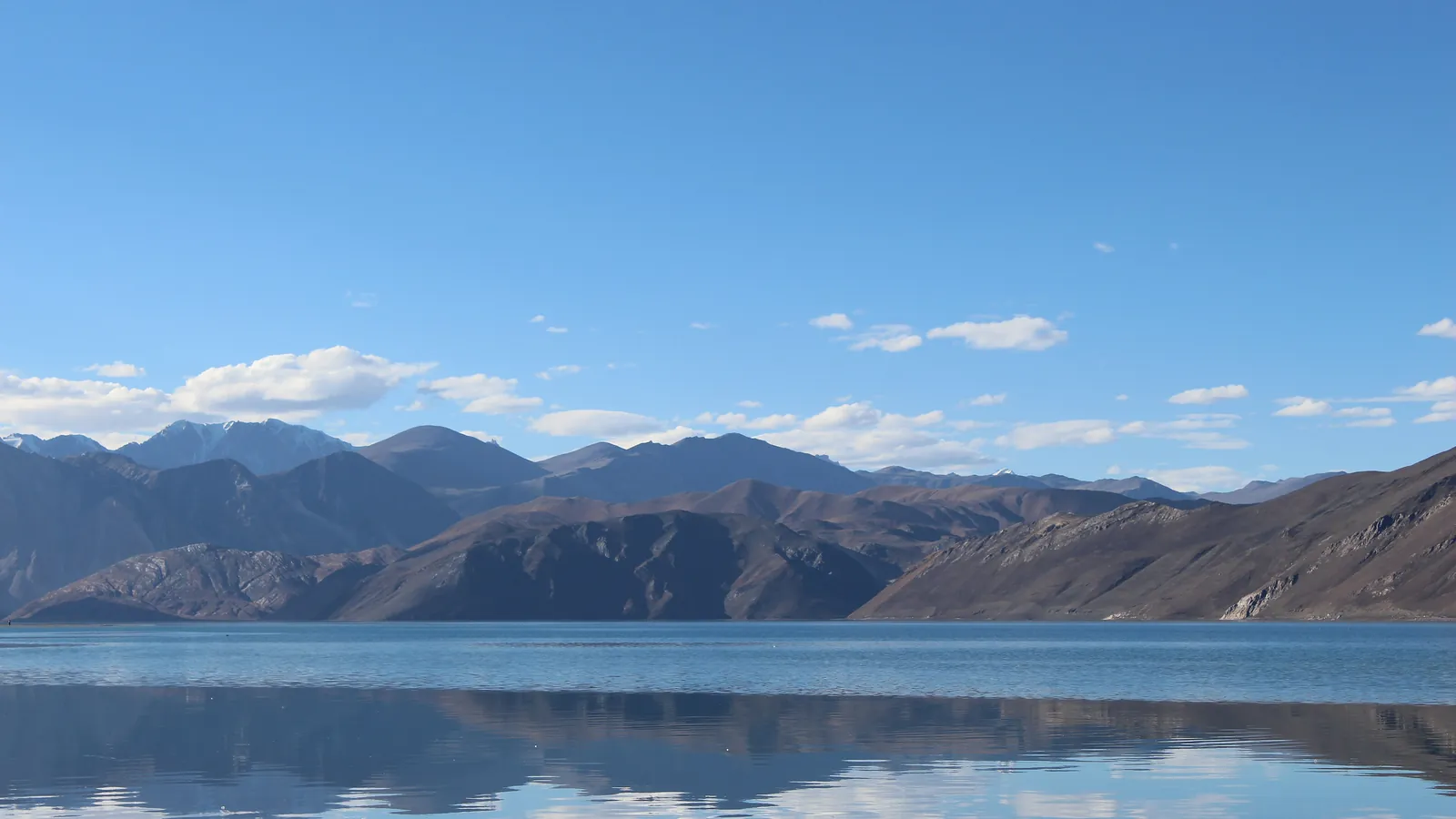 Pangong Tso in Ladakh, a high-altitude lake whose waters shift between navy, turquoise and green against bare mountains
