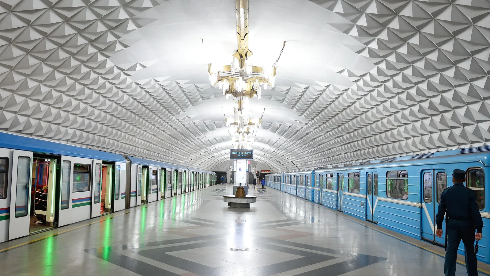 The ornate interior of a Tashkent Metro station, decorated with chandeliers and patterned ceilings